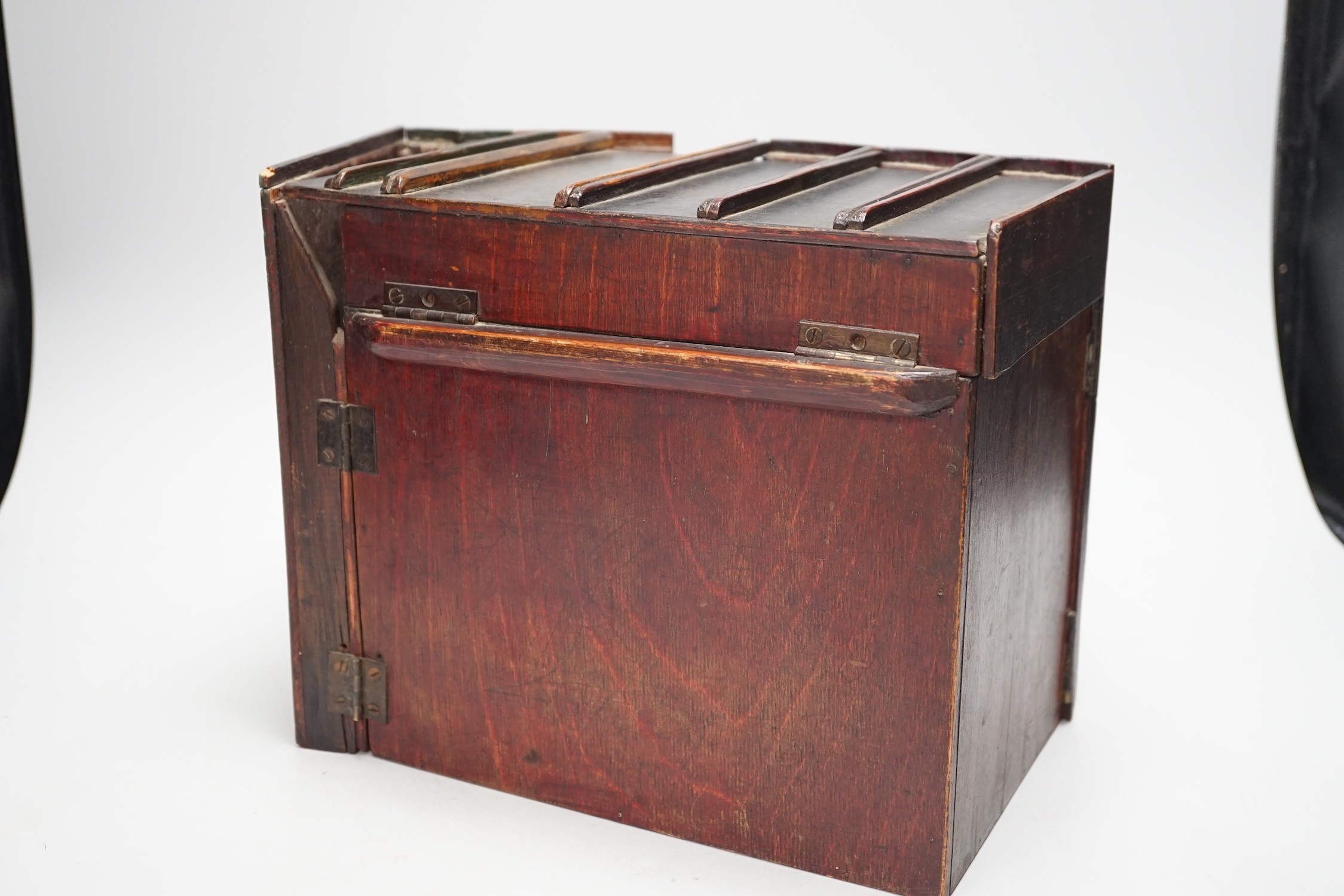 An early 20th century painted carved oak novelty stationary box modelled as books, 27cm wide, 23cm tall, 16cm deep